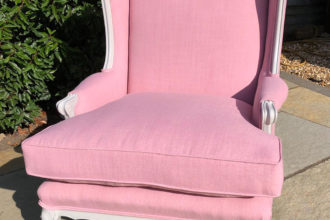 American winged back chair recovered in pink linen with new fibre filled seat cushion