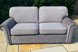 A 3 seater settee recovered in plain and patterned fabric with new cushions