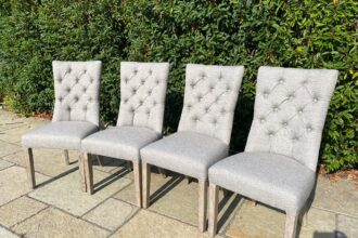 A set of button back dining chairs recovered in a faux linen