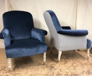 A pair of old armchairs recovered in blue velvet, with contrasting fabric on the outside of each